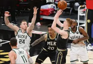  ?? Kevin C. Cox / Getty Images ?? Kevin Huerter of the Hawks shoots against Pat Connaughto­n (24) of the Bucks during the second half Tuesday. Huerter had 15 points, seven assists and six rebounds as Atlanta evened the series at two wins apiece.