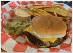  ?? (Arkansas Democrat-Gazette/Eric E. Harrison) ?? The regular cheeseburg­er with fries at Hubcap Burger Co. is way more doable than the namesake Hubcap Burger.