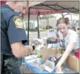  ??  ?? Christine Daywatt shows police Officer Jime Browne of Hilltown Township the different raffle baskets.