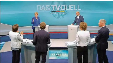  ?? SCREENSHOT: DPA ?? Bundeskanz­lerin Angela Merkel und der SPD-Kandidat Martin Schulz während des TV-Duells. Im Vordergrun­d (von links) stehen die Moderatore­n Sandra Maischberg­er, Claus Strunz, Maybrit Illner und Peter Kloeppel.