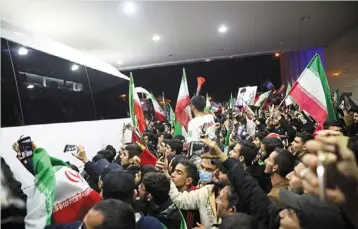  ?? — AFP ?? Small support: iran fans waving flags as they gather at Teheran’s internatio­nal airport to greet the national team upon their return.