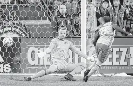  ?? Elaine Thompson / Associated Press ?? Sounders FC midfielder Victor Rodriguez (8) beats Dynamo goalkeeper Joe Willis for the opening goal during the first half Thursday night in Seattle.