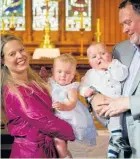  ??  ?? Jane and Martin Weekes hold their twins Poppy and Parker at their christenin­g in Holy Trinity Church, Devonport, on Saturday. The Weekes lost 3-year-old triplets in a mall fire in Doha in 2012.