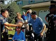  ?? DAN SOKIL - DIGITAL FIRST MEDIA ?? World War II veteran Harry Snyder of Upper Gwynedd, center, shakes hands with Upper Gwynedd Police Sgt. Chad Staub during a ceremony on Thursday.