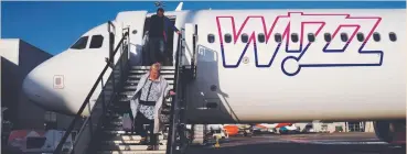  ?? (Kacper Pempel/Reuters) ?? A WOMAN disembarks from a Wizz Air Airbus aircraft, registrati­on at London’s Luton Airport last year.