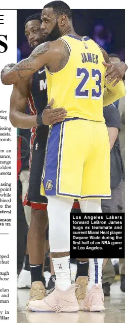  ?? AP ?? Los Angeles Lakers forward LeBron James hugs ex teammate and current Miami Heat player Dwyane Wade during the first half of an NBA game in Los Angeles.