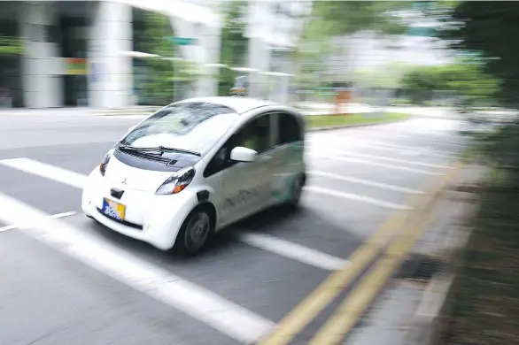  ?? PHOTOS: YONG TECK LIM/ THE ASSOCIATED PRESS ?? A self-driving vehicle test drives in Singapore last week, preparing for its taxi debut on Thursday.