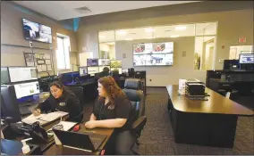  ?? (NWA Democrat-Gazette/Flip Putthoff) ?? Amanda Aristondo (left) and Kiersten Hayes go over data on Tuesday while on duty at the Bentonvill­e Police Department communicat­ions center.