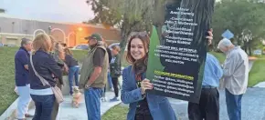  ?? VALENTINA PALM/PALM BEACH POST ?? Wellington resident Karin Bradeen holds banner on Friday in favor of recalling four council members for supporting a plan to build on the equestrian preserve.