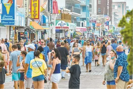  ?? JERRY JACKSON/BALTIMORE SUN ?? Many visitors to the Ocean City boardwalk opted not to wear masks Tuesday despite signs recommendi­ng them.