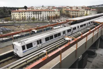  ?? Photos by Michael Short / Special to The Chronicle ?? A train leaves Pleasant Hill BART Station, with the Avalon Walnut Creek Apartments in the background, the type of denser developmen­t around transit hubs SB827 would encourage.