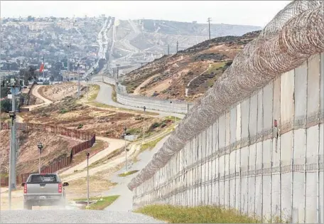  ?? Bill Wechter AFP/Getty Images ?? THE BORDER FENCE in San Diego. Currently, about 600 miles of the 2,000-mile-long border with Mexico have some form of fence.