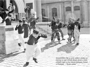  ??  ?? Schoolchil­dren flee as army soldiers conduct an exercise to repel militant attacks detain a mockmilita­nt (right) at the Islamia Collegiate School in Peshawar. — Reuters photo