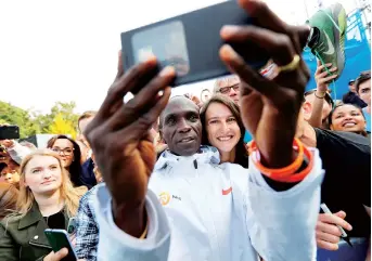  ??  ?? Kenya’s Eliud Kipchoge takes a seflie with fans after winning the Berlin Marathon and breaking the world record. — Reuters