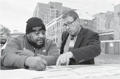  ?? LLOYD FOX/BALTIMORE SUN ?? Terry Stringfiel­d, left, a pest control worker with the city, and Ken Strong, a special assistant with the Baltimore Housing Authority, talk about the number of rat burrows and other problems that were found at Douglass Homes.