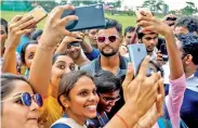  ??  ?? Suresh Raina poses for a selfie with fans.