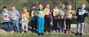  ?? ?? Drumlemble’s primary one to three children holding their sunflower pictures.