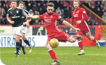  ??  ?? Aberdeen’s Graeme Shinnie strikes the winner at Pittodrie