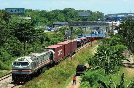  ??  ?? TREN kargo dengan muatan yang tergelinci­r berhampira­n Stesen Batu Tiga, semalam.