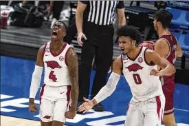  ?? DARRON CUMMINGS / AP ?? Davonte Davis (left) celebrates with Arkansas teammate Justin Smith after Davis sank a basket as time expired in the first half of a tournament game Friday against Colgate at Bankers Life Fieldhouse in in Indianapol­is. Arkansas won 85-68.