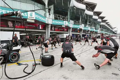  ??  ?? Warming up: The Haas support team stretching before a pit stop practice ahead of the Malaysian Formula 1 Grand Prix at the Sepang Internatio­nal Circuit yesterday.