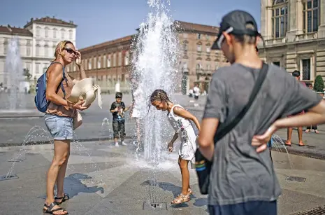  ?? (AFP) ?? People cool themselves in a fountain at Piazza Castello, in Turin on August 2 as heatwaves continue to grip southern Europe