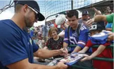  ?? ERNIE MASCHE/THE HICKORY DAILY RECORD/THE ASSOCIATED PRESS ?? Tim Tebow signs autographs before a game in the South Atlantic League, which is seeing a burst in attendance whenever Tebow is in the lineup.