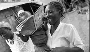  ??  ?? Mariatu Sesay, 15, smiles as she carries her daughter Nadia while she walks outside her house in the countrysid­e village of Sierra Leone July 11, 2019. (Photo: Reuters)