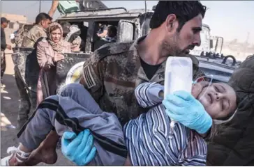  ?? SERGEY PONOMAREV/THE NEW YORK TIMES ?? Medics carry a child wounded during fighting to a field hospital on the outskirts of Mosul on Wednesday.