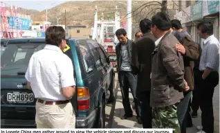  ??  ?? In Longde China men gather around to view the vehicle signage and discuss our journey.