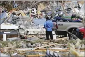  ?? MARK HUMPHREY — THE ASSOCIATED PRESS ?? A man looks for items he can salvage from his store Tuesday near Cookeville, Tenn. Tornadoes ripped across Tennessee early Tuesday, killing two dozen people.