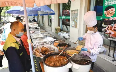  ?? Picture: AFP ?? SAFE ROAD. An employee prepares takeout food outside a restaurant after the government banned dining at restaurant­s to curb the spread of the Covid virus in Beijing yesterday.