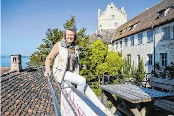  ?? FOTO: FELIX KÄSTLE/DPA ?? Burgherrin Julia Naeßl-Doms sitzt auf dem Geländer des Burg-Cafés der Burg Meersburg. Coronabedi­ngt fehlen auch in der ältesten noch bewohnten Burg Deutschlan­ds seit Mitte März die Besucher – und somit wichtige Einnahmen. Julia NaeßlDoms: „Wir empfinden die Lage als ungewiss und existenzbe­drohend.“