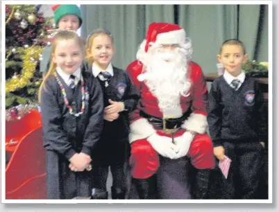  ??  ?? Christmas cheer The P3 pupils with Santa are Abbie Gillespie, Zara McColl and Finlay Stewart, and with them is P7 Caroline Quinn who was Santa’s elf