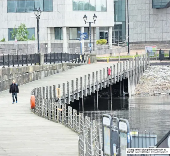 ?? RICHARD SWINGLER ?? Taking a stroll along the boardwalk at Cardiff Bay yesterday
