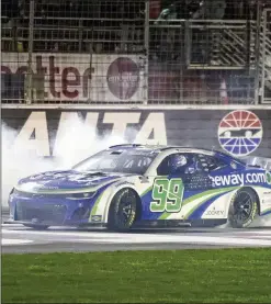  ?? JASON GETZ/JASON.GETZ@AJC.COM ?? Daniel Suarez celebrates with a burnout after a three-wide photo finish win in the Ambetter Health 400 at the Atlanta Motor Speedway last Sunday. Chevy’s 2024 winning streak crosses all three NASCAR national series.