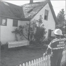  ?? JIM DAY/THE GUARDIAN ?? New Glasgow fire department chief Jason Peters checks out the damage to the roof of the historic Green Gables Post Office in Cavendish. A fire started in the building late Monday afternoon.