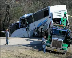  ??  ?? Employees from a wrecker service work to remove a charter bus from a roadside ditch on Monday, after it crashed alongside Interstate 30 near Benton, Ark. Josh BrIggs/sAlIne CourIer VIA AP