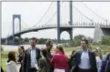  ?? MARK LENNIHAN — THE ASSOCIATED PRESS ?? Eric Trump, third from left, and Donald Trump Jr., right, talk with guests at the opening of the Trump Golf Links clubhouse, Monday in the Bronx borough of New York. Behind them is the Whitestone Bridge.