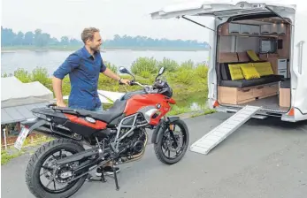  ?? FOTO: DPA ?? Große Klappe: In diesem Reisemobil parkt das Motorrad während der Fahrt direkt im Wohnzimmer.