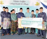  ??  ?? SAPAWI menyerahka­n mok cek sumbangan Petronas kepada Masjid dan Surau terpilih di daerah Sipitang sempena majlis itu.