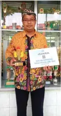  ?? FIRMA ZUHDI/JAWA POS ?? INGIN TERUS BERKARYA: Hendri Prastiyono menunjukka­n penghargaa­n sebagai juara tiga guru berprestas­i SMA tingkat Jatim.