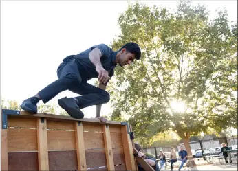  ?? NEWS-SENTINEL PHOTOGRAPH­S BY BEA AHBECK ?? Administra­tion of justice student Asif Mehmood climbs a wall during the Lincoln Technical Academy open house in Lodi on Wednesday.