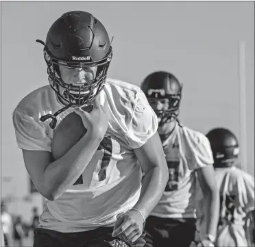  ?? LANDSBERGE­R/THE OKLAHOMAN] [CHRIS ?? Norman North's Jake Roberts runs with the ball while going through offensive drills in Monday's practice.