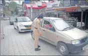  ?? DEEPAK SANSTA/HT ?? A woman cop stopping vehicles for checking during the second day of Covid curfew at Sanjauli in Shimla on Saturday.