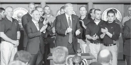  ?? Jim Watson AFP/Getty Images ?? PRESIDENT TRUMP signed the rollback of his predecesso­r’s climate efforts while surrounded by coal miners at EPA headquarte­rs.