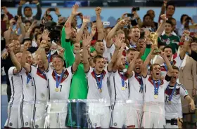 ?? Associated Press ?? Can Germany repeat?: In this July 13, 2014 file photo, Germany's Philipp Lahm holds up the World Cup trophy as the team celebrates their 1-0 victory over Argentina after the World Cup final soccer match between Germany and Argentina at the Maracana Stadium in Rio de Janeiro, Brazil. The soccer world gathers at 12 stadiums in 11 cities across the European portion of Russia starting June 14 for a 32-day, 64-match World Cup.