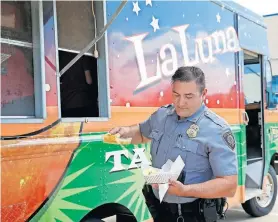  ?? [SARAH PHIPPS/ THE OKLAHOMAN] ?? Sgt. Jesse Childers gets his food at the La Luna Taco Truck at the Oklahoma City Fraternal Order of Police lodge on Tuesday. The truck served law enforcemen­t officers, firefighte­rs, EMSA workers and health care workers.