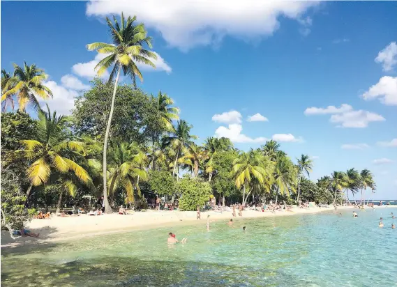  ?? PHOTOS: MAURA JUDKIS/THE WASHINGTON POST ?? Visitors enjoy the sun, sand and warm water of Plage de la Caravelle, a beach on Guadeloupe’s Grande-Terre island.