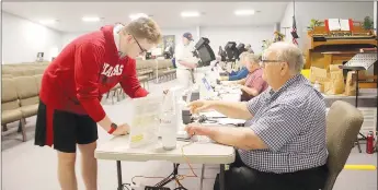  ?? LYNN KUTTER ENTERPRISE-LEADER ?? Noah Farmer, 18, of Farmington, votes for the first time in the May 24 primary election. Election worker Randy Campbell said he’s been helping with the polling place at Main Street Baptist Church in Farmington for many years.